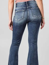 Blue jeans worn by a person on a plain background