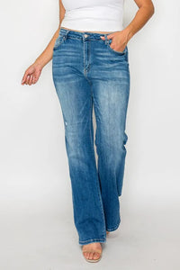Person wearing blue jeans and a white top on a plain background