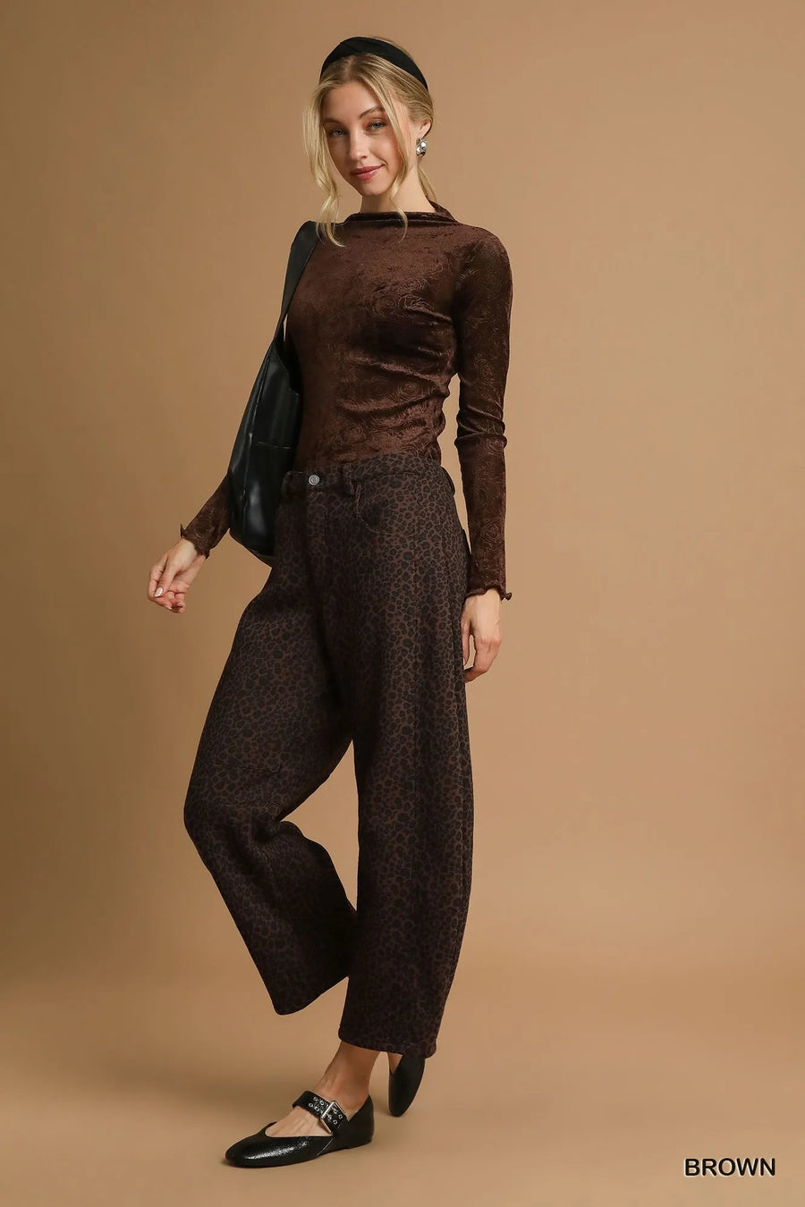 Woman wearing a brown outfit against a beige background
