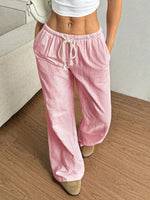 Person wearing pink striped pants and a white top on a wooden floor.