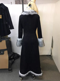 Black coat with fur trim on a mannequin against a white wall.