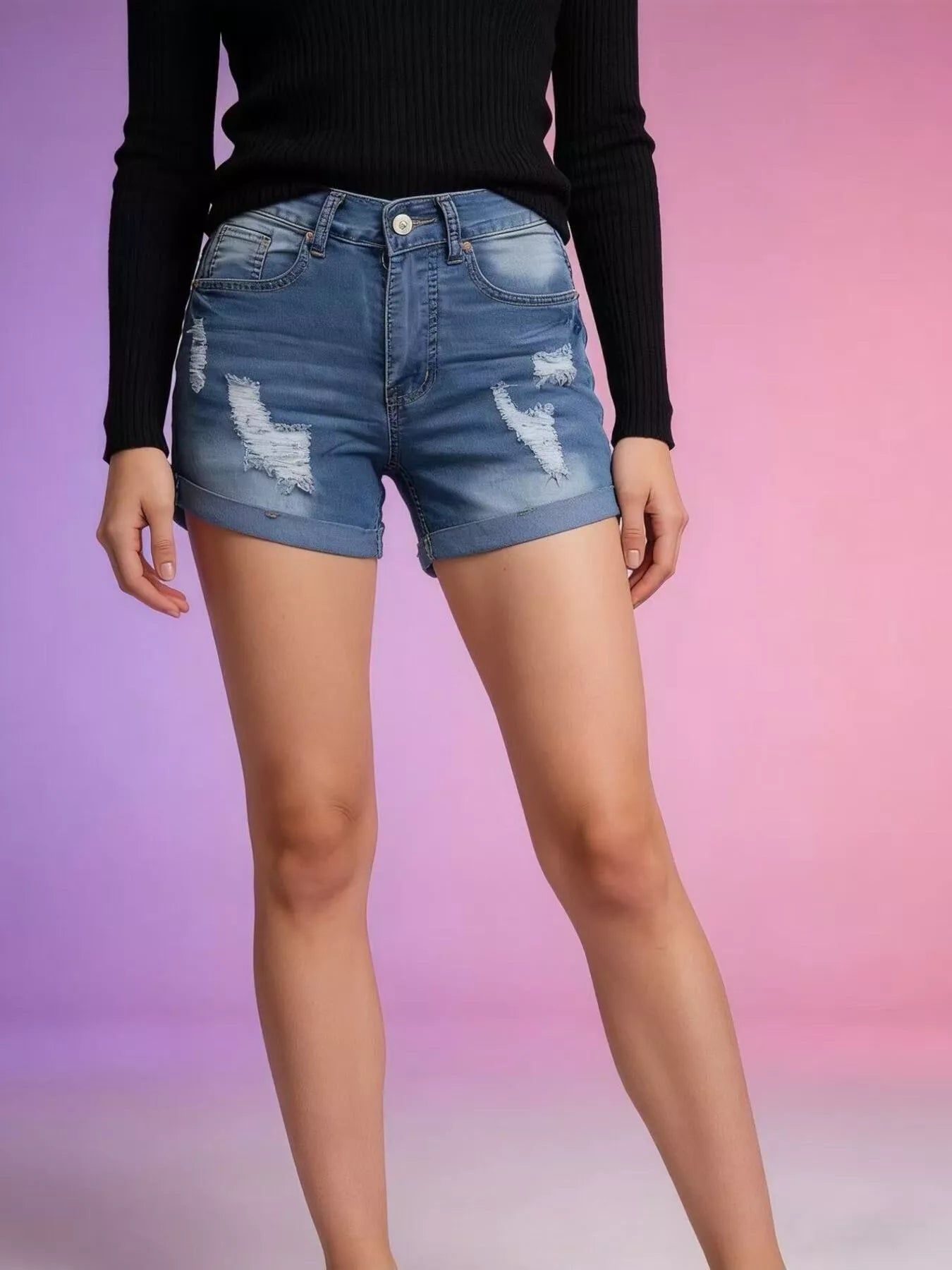 Person wearing blue denim shorts with a black long-sleeve top on a gradient background