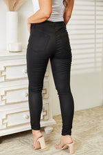 Person wearing black pants standing in a room with a white dresser.