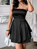 Woman wearing a black strapless dress in an indoor setting