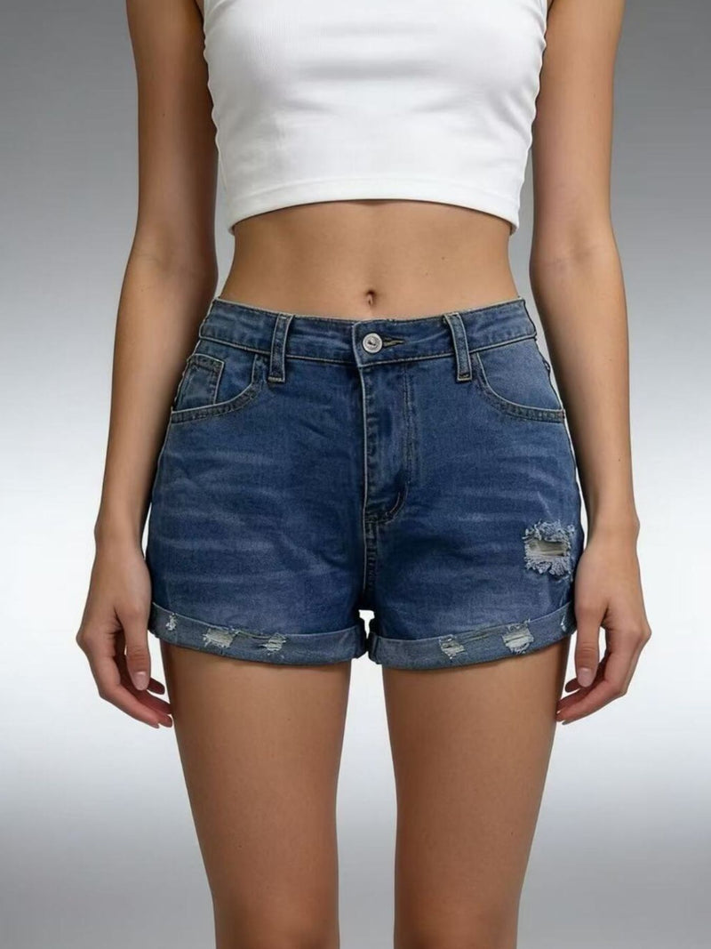 Person wearing blue denim shorts and a white crop top on a gray background