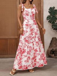 Woman wearing a white dress with red floral pattern indoors.