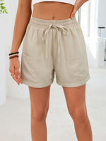 Beige shorts worn by a person on a white background
