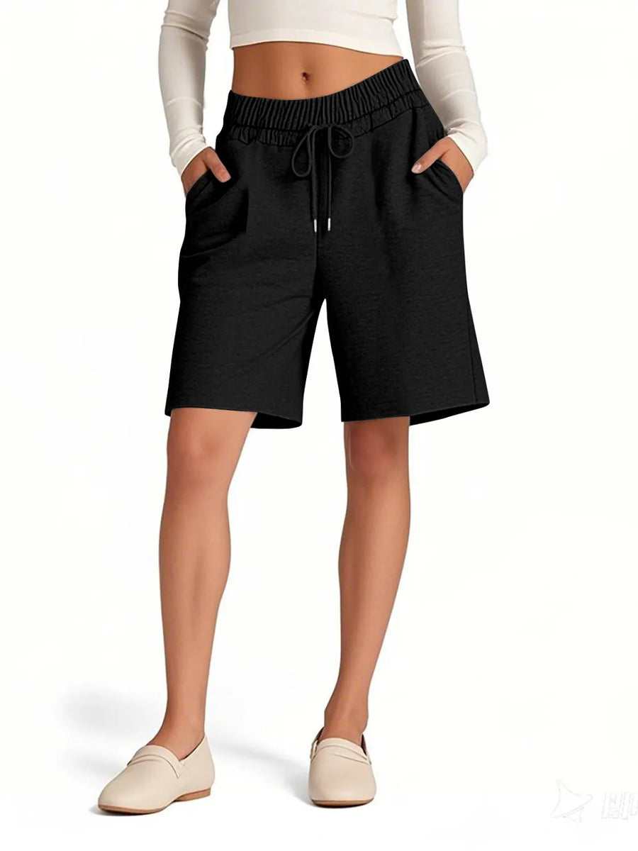Person wearing black shorts with a white background