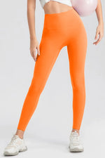 Person wearing bright orange leggings on a light gray background