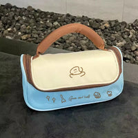 Blue and beige bag with cartoon character design on a dark surface