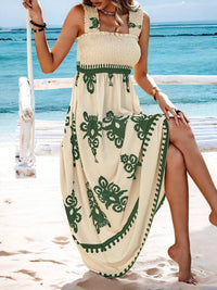 Woman in a white dress with green patterns on a beach
