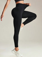 Person wearing black leggings and white sneakers on a plain background