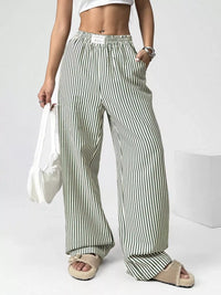 Person wearing green and white striped pants on a plain background