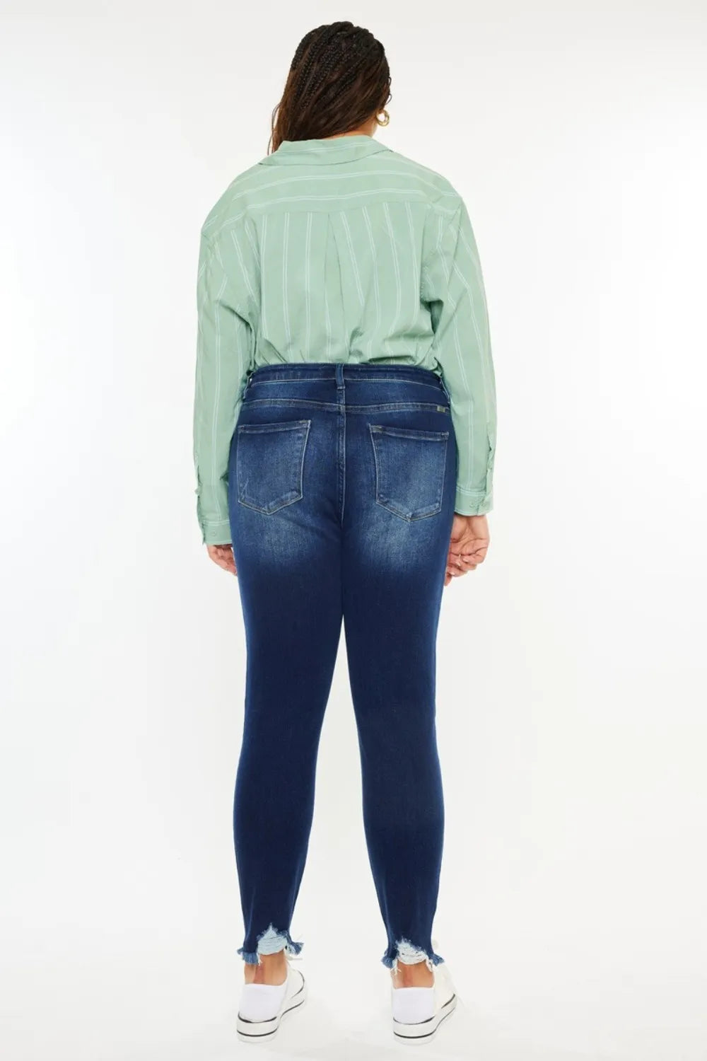 Person wearing a green shirt and blue jeans on a white background