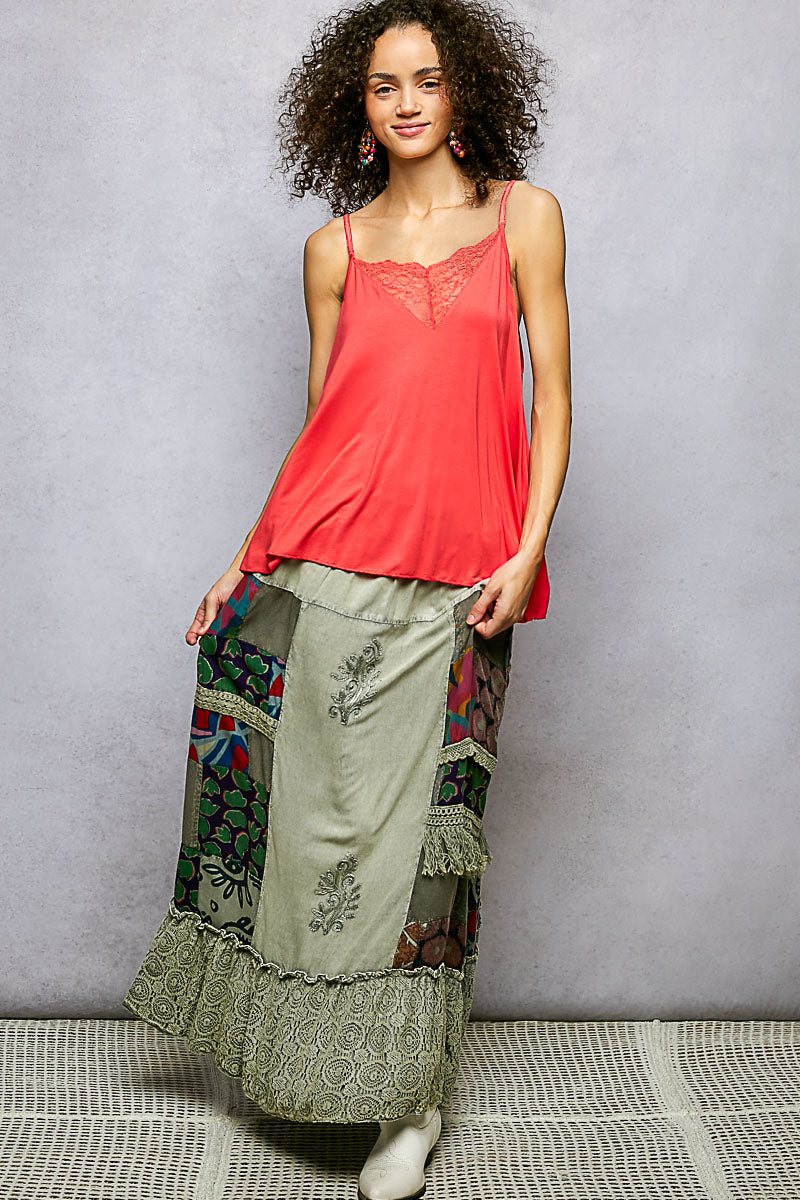 Woman wearing a red top and patterned pants against a gray background