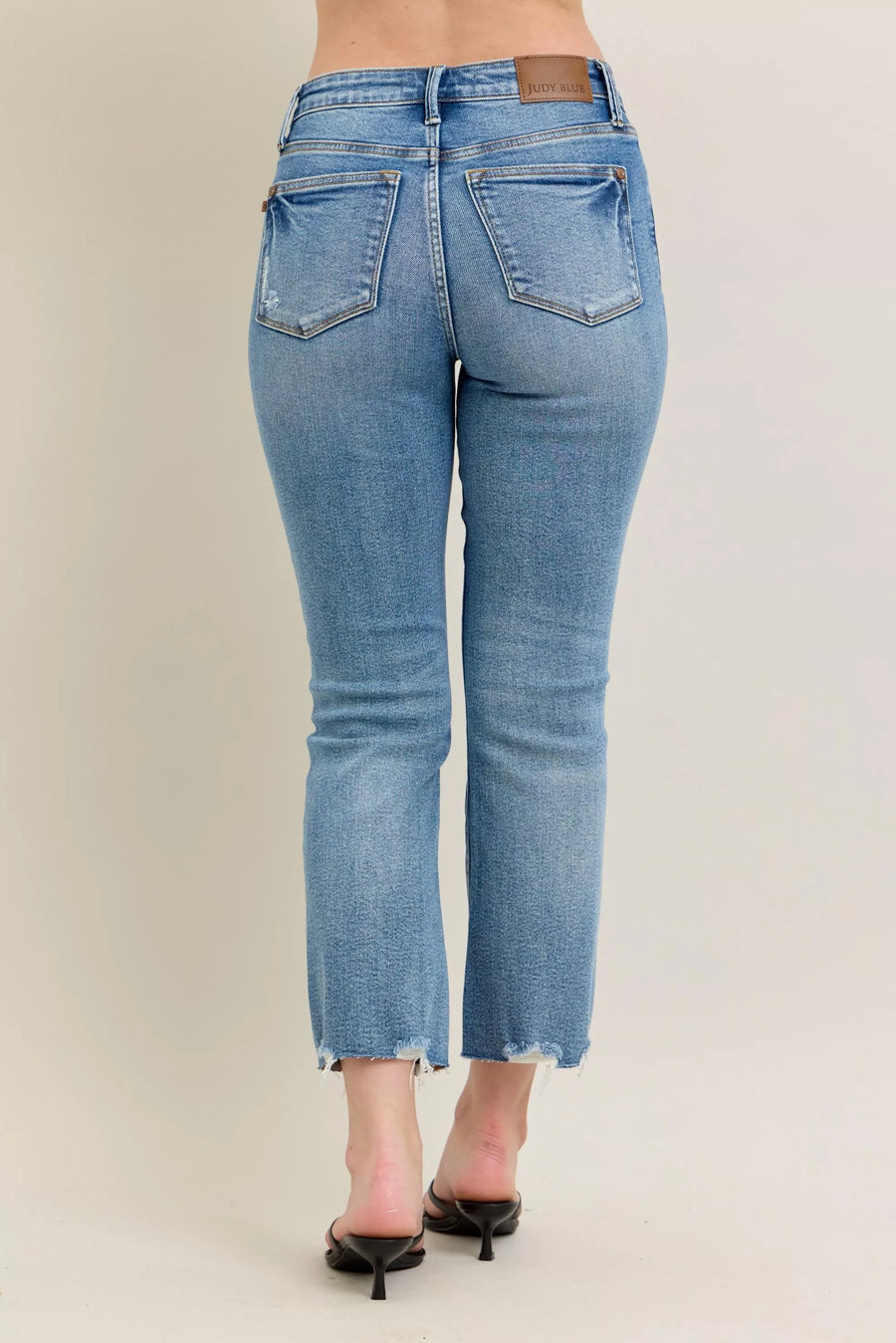 Light blue jeans worn by a person on a plain background