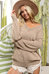 Woman wearing a beige sweater and hat in front of cacti