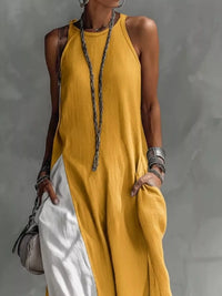 Person wearing a yellow sleeveless dress with a gray background