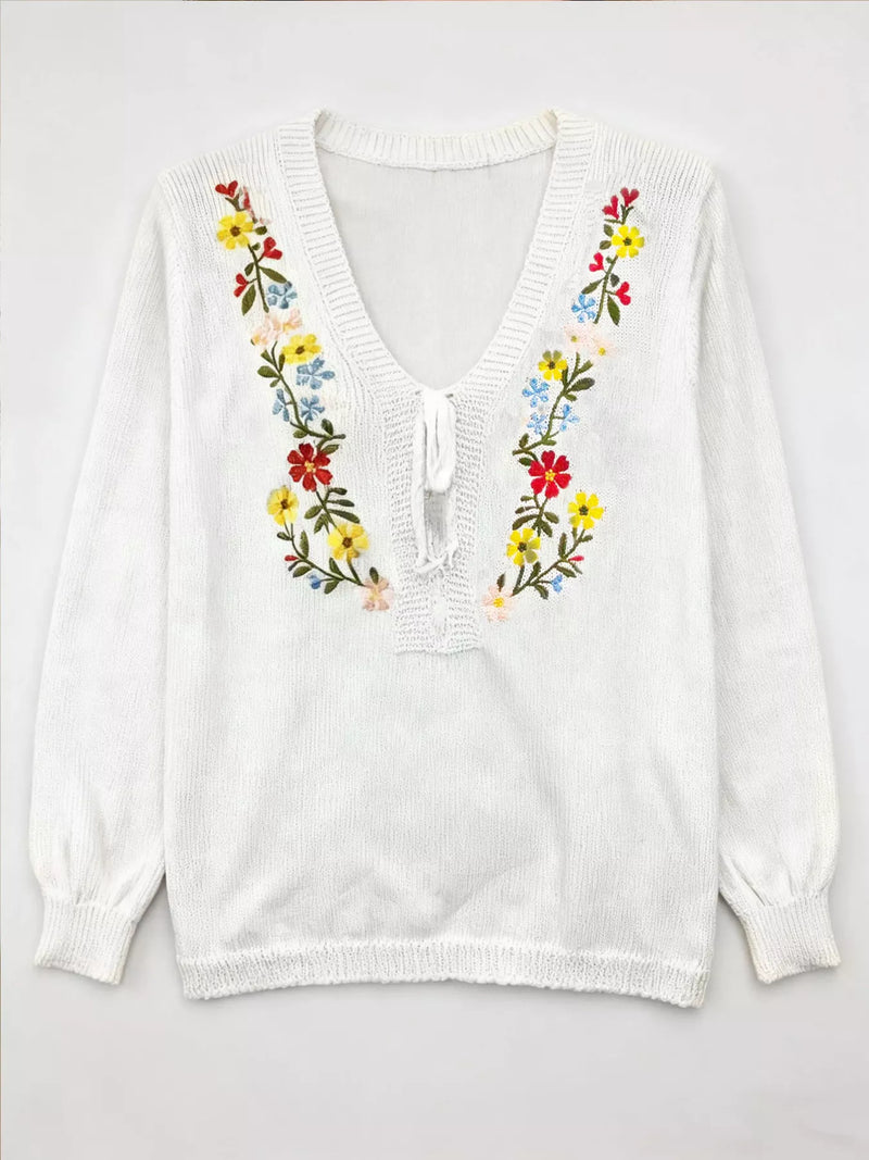 White blouse with colorful floral embroidery on a white background