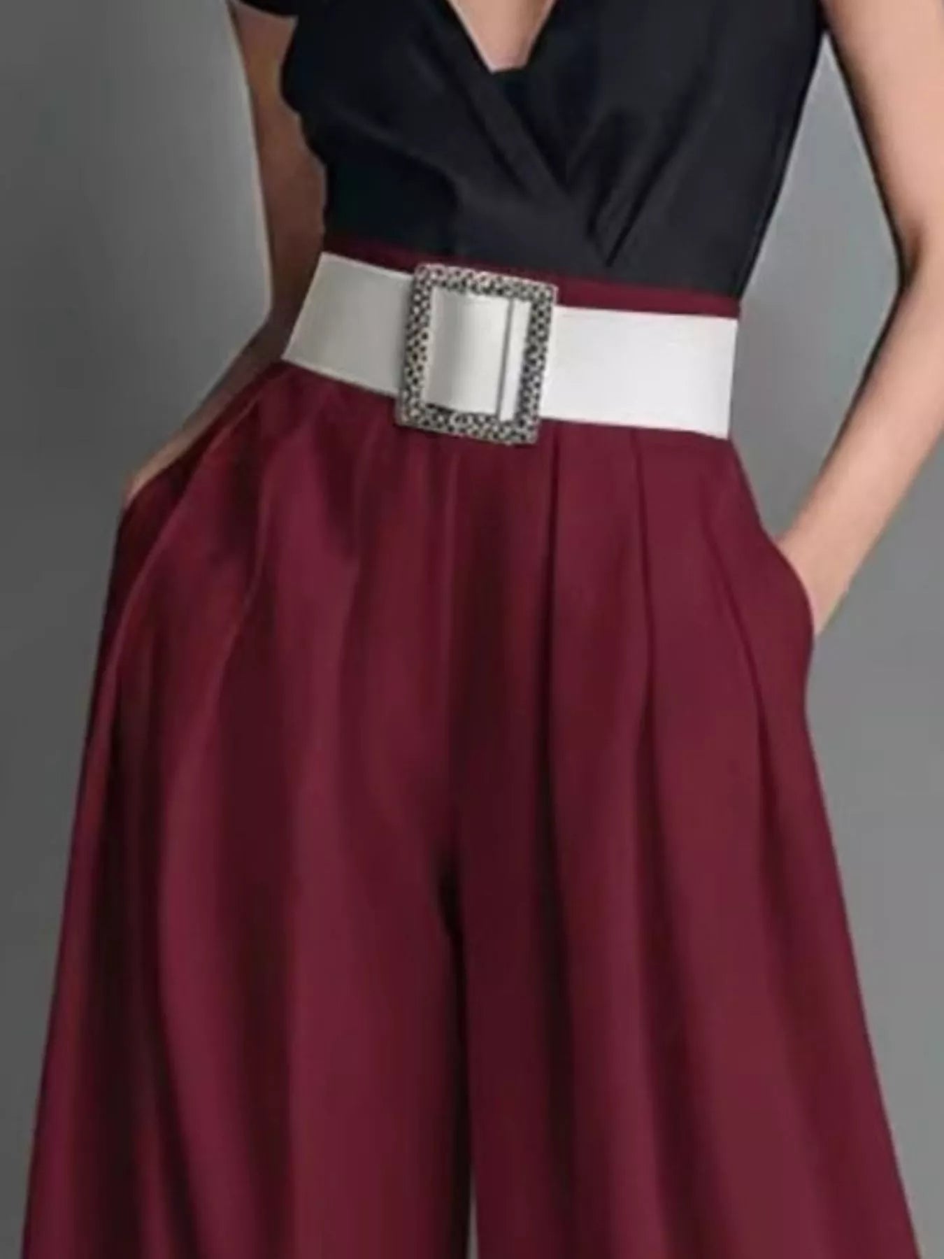 Maroon skirt with a white belt and decorative buckle on a gray background
