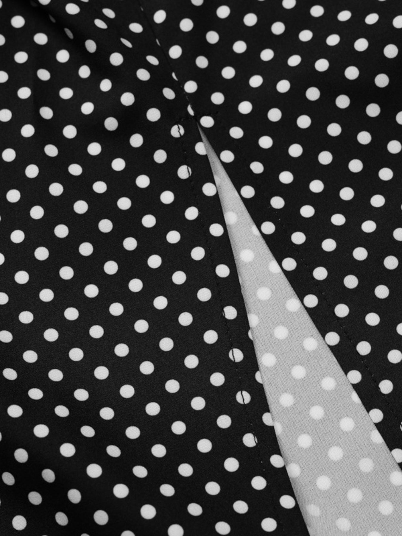 Black fabric with white polka dots and a diagonal white stripe.