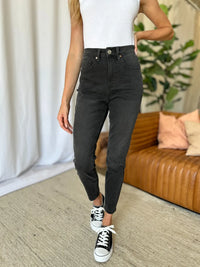 Person wearing black jeans and white sneakers in a living room setting