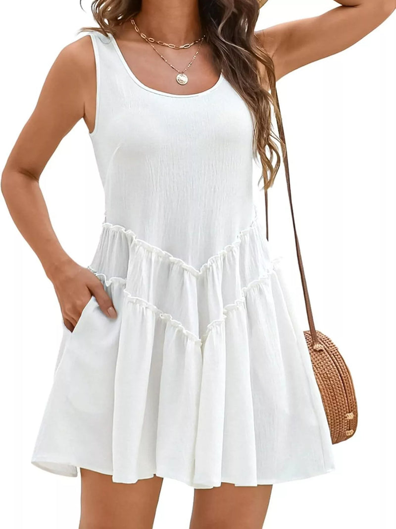 Woman wearing a white sleeveless dress with a ruffled skirt on a plain background
