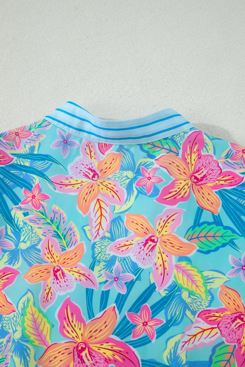 Colorful floral patterned shirt on a light gray background