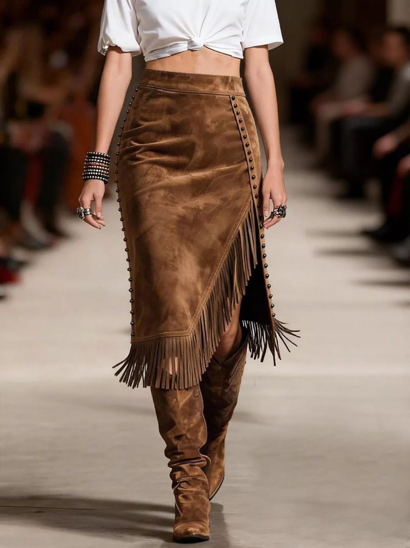Model walking on a runway wearing a brown suede skirt with fringe and matching boots.