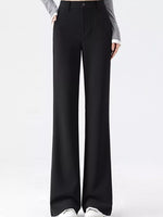 Black wide-leg trousers shown on a model from the waist down, paired with a gray long-sleeve top and white sneakers against a plain white studio background.