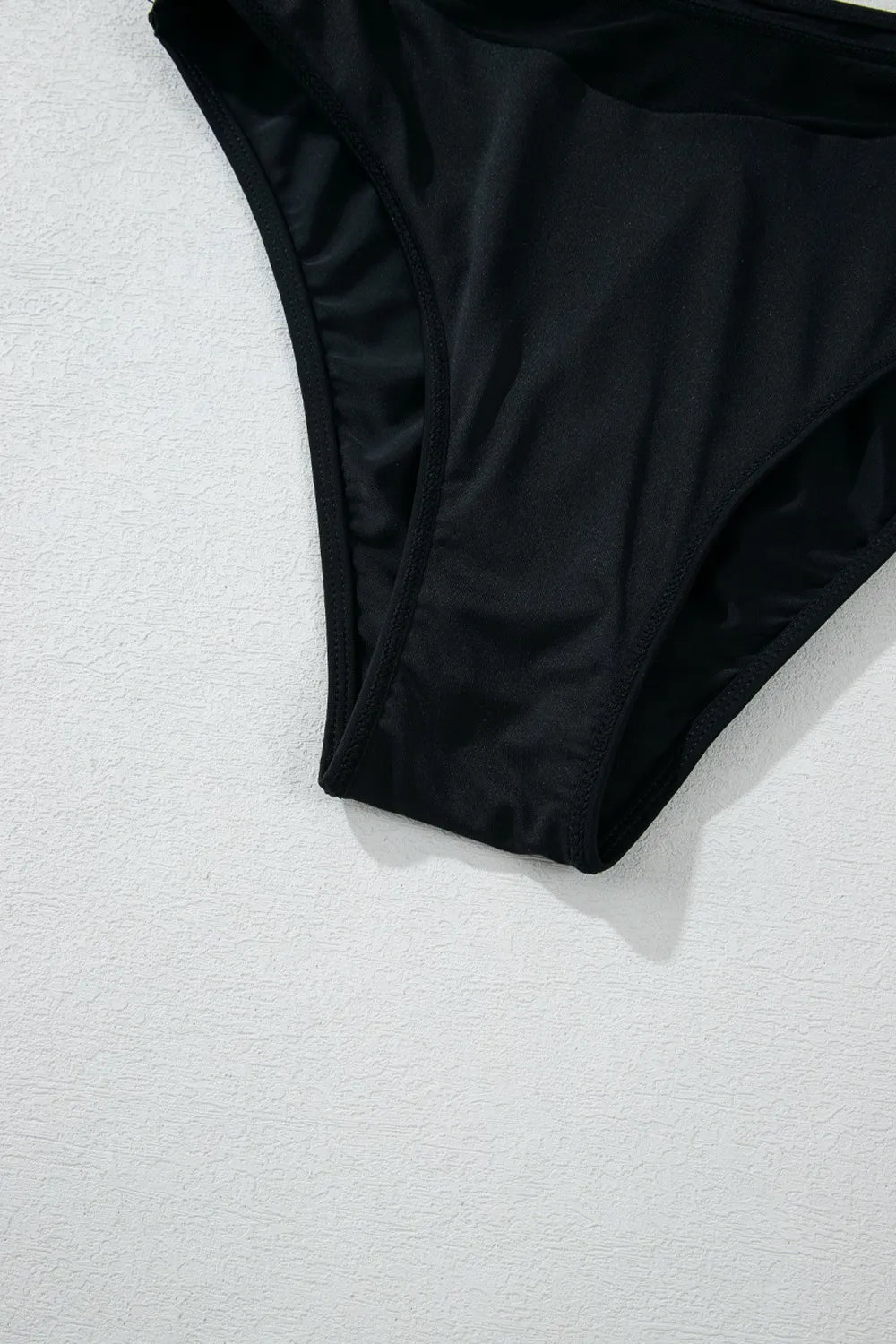 Black bikini bottom on a textured white surface
