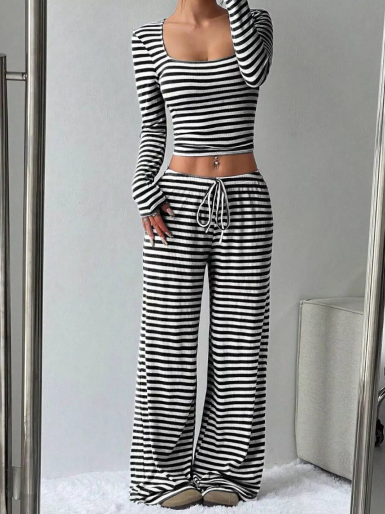 Person wearing a black and white striped outfit in front of a mirror.