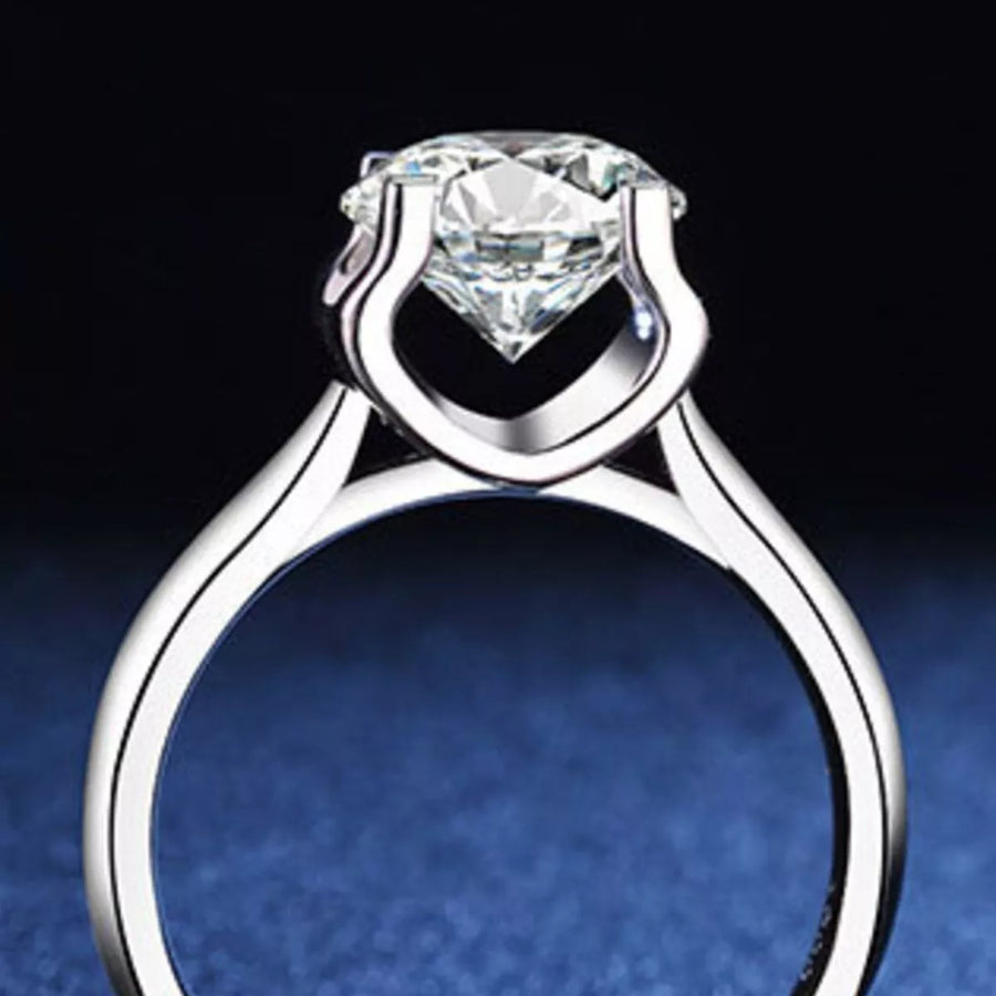 Silver ring with a large diamond on a dark background