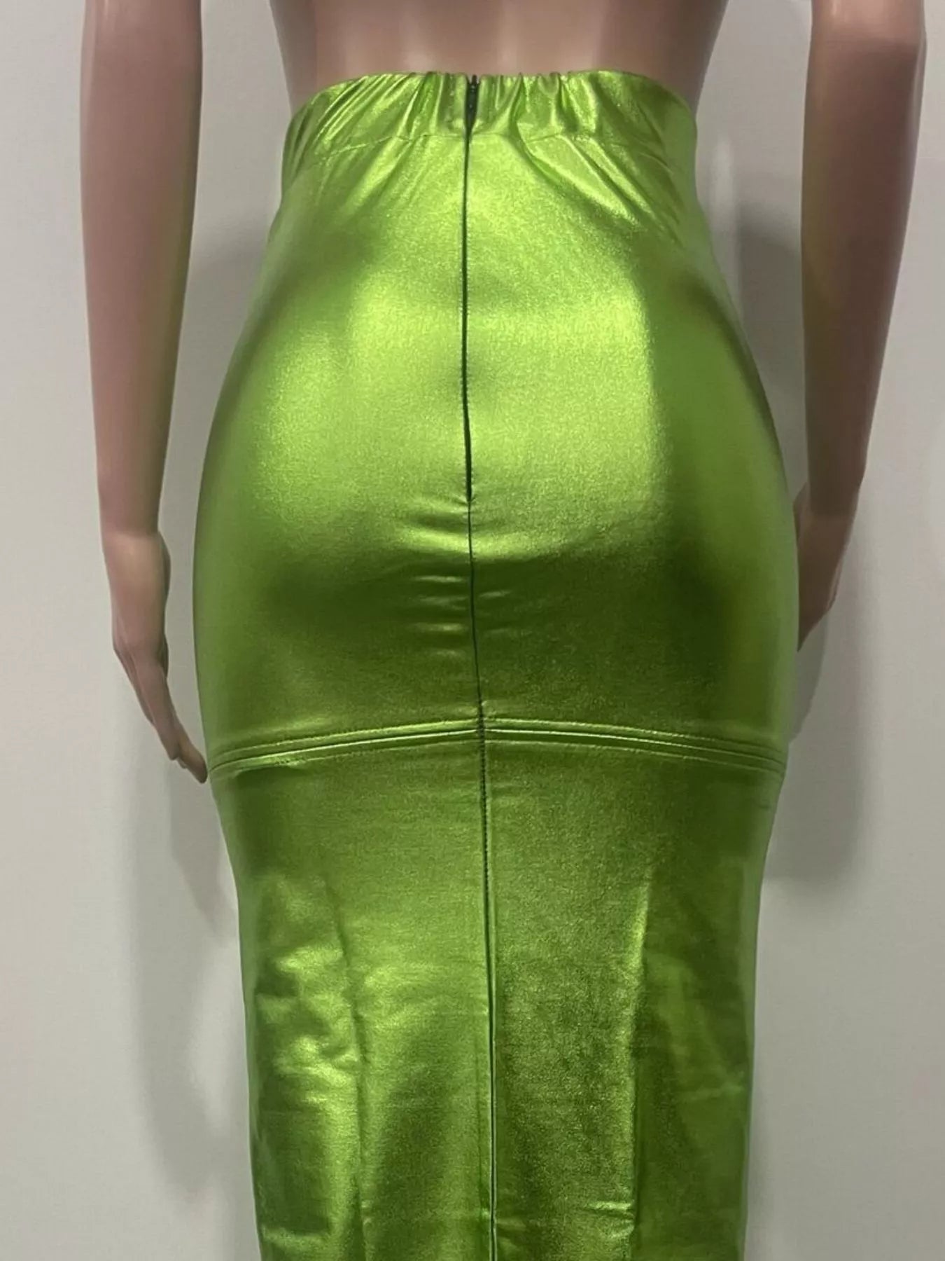Green metallic skirt worn by a mannequin against a plain background