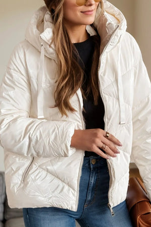 Person wearing a white puffer jacket with a blurred background