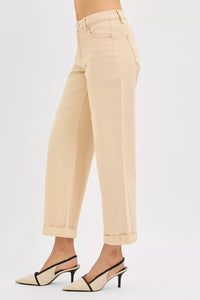 Beige pants worn by a person on a white background