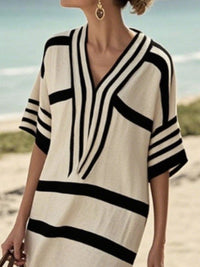 Woman wearing a black and white striped dress on a beach