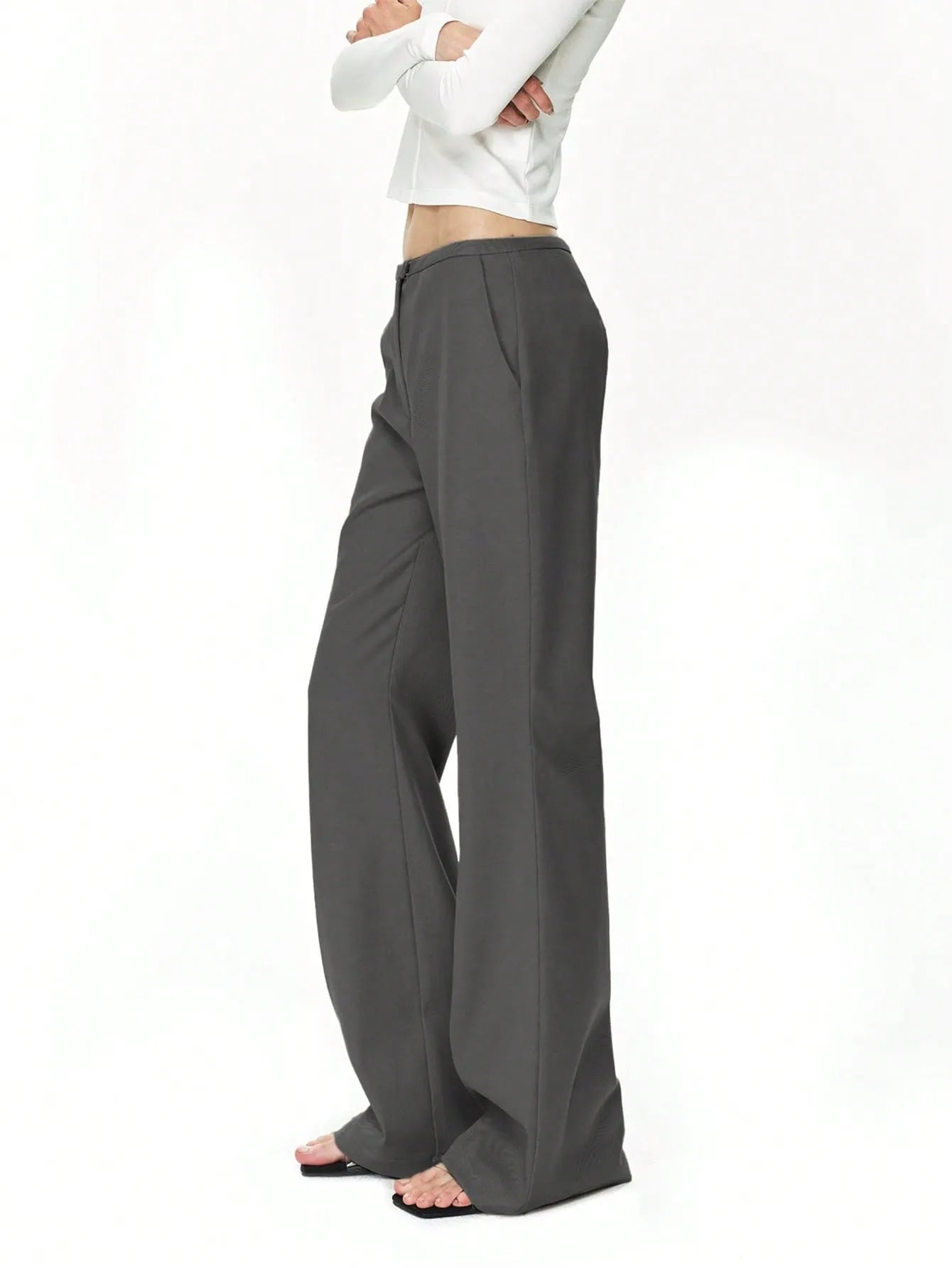 Person wearing gray wide-leg pants on a white background