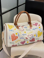 White duffel bag with colorful heart and text patterns on a white chair.