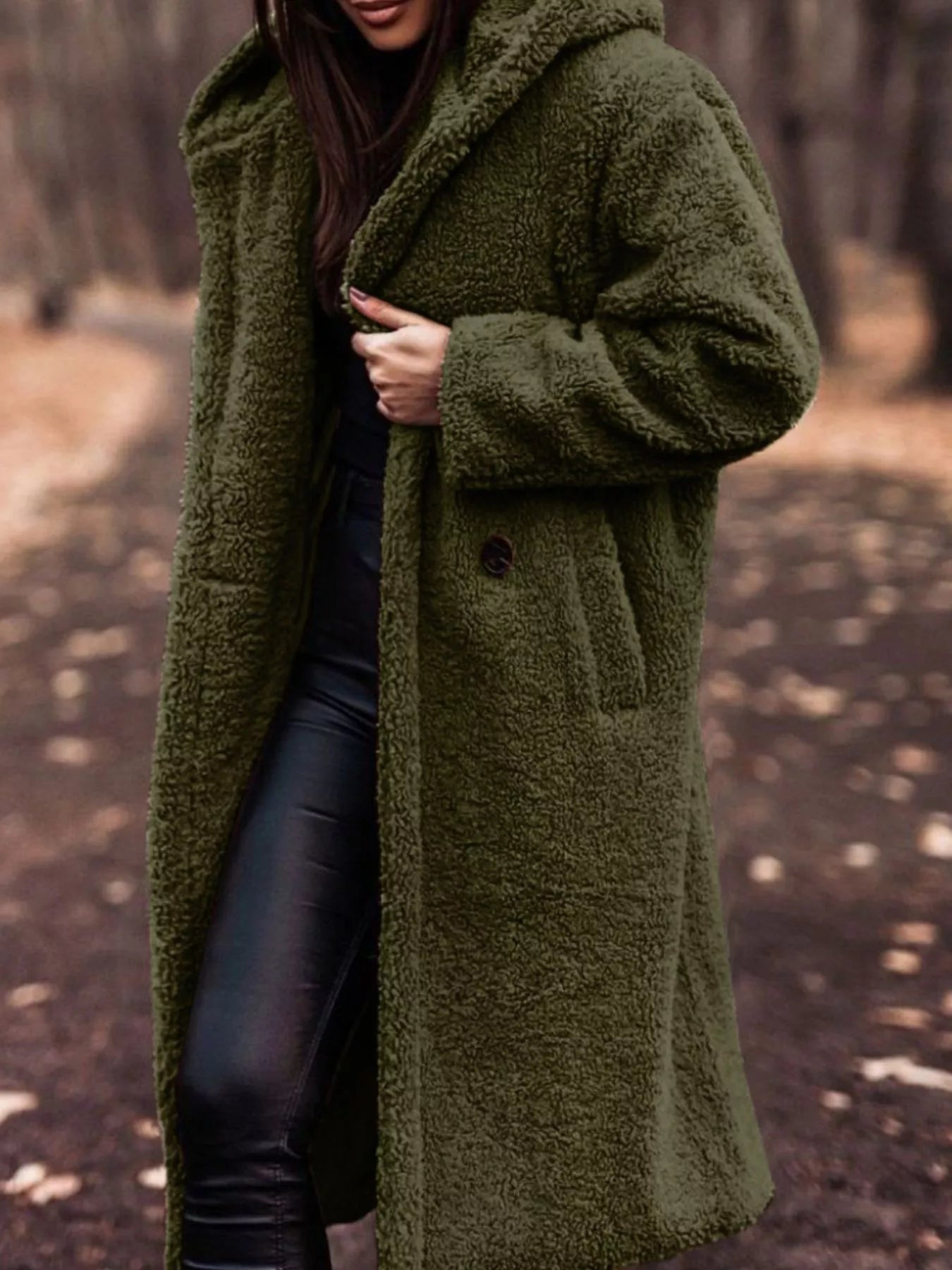 Person wearing a green coat in a forest setting