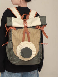 Person wearing a multi-colored backpack with a neutral background