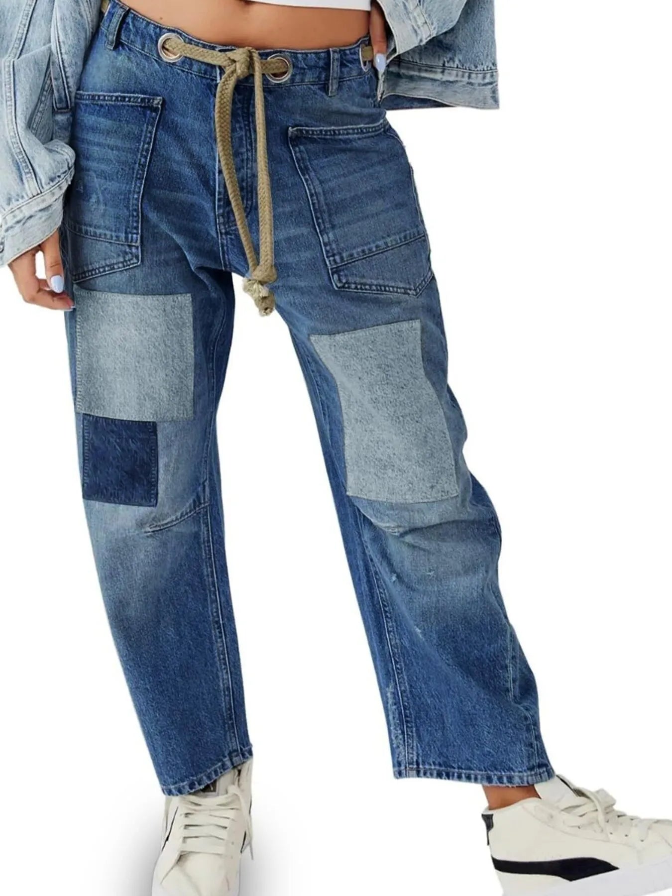 Blue patchwork jeans worn by a person on a white background