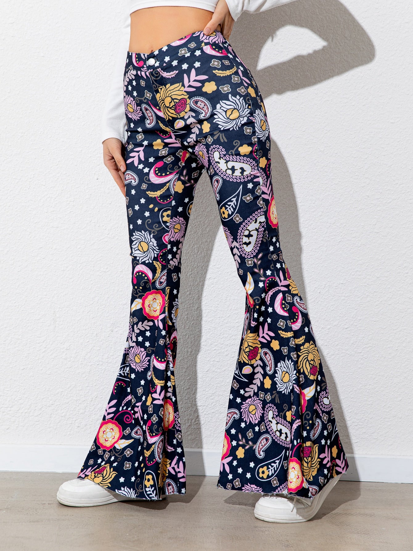 Flared pants with colorful pattern worn by a person on a white background