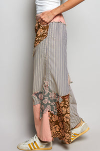 Person wearing a patchwork skirt with various patterns and colors on a plain background