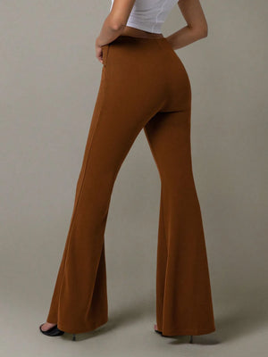 Brown flared pants worn by a person on a plain background