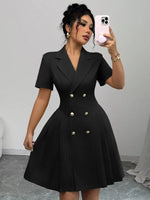 Woman wearing a black dress with buttons, taking a mirror selfie.
