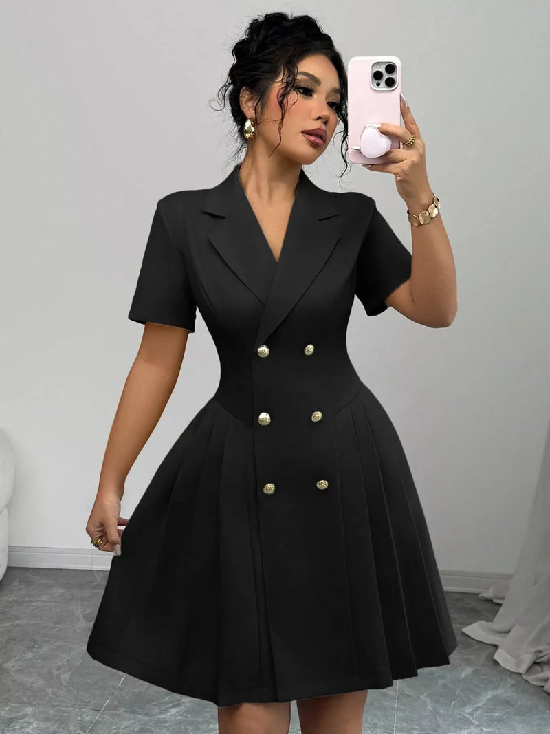 Woman wearing a black dress with buttons, taking a mirror selfie.