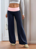 Person wearing navy wide-leg pants with a pink waistband indoors.