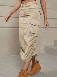 Person wearing beige cargo pants and tan boots on a neutral background