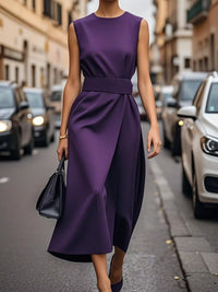 Person wearing a purple dress on a city street with cars and buildings in the background